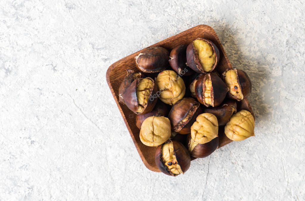 Roasted chestnut. Grilled chestnuts on wooden plate.