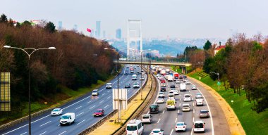 İSTANBUL, TURKEY - 12 HAZİRAN 2021: Fatih Sultan Mehmet Köprüsü arka planında otoyolda trafik. İstanbul, Türkiye.