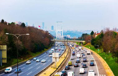 İSTANBUL, TURKEY - 12 HAZİRAN 2021: Fatih Sultan Mehmet Köprüsü arka planında otoyolda trafik. İstanbul, Türkiye.
