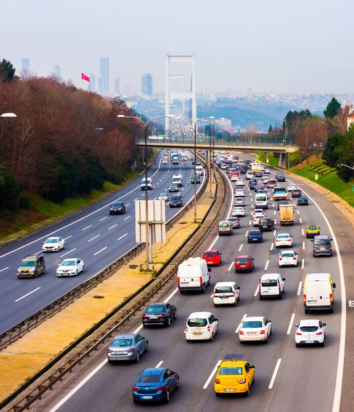 İSTANBUL, TURKEY - 12 HAZİRAN 2021: Fatih Sultan Mehmet Köprüsü arka planında otoyolda trafik. İstanbul, Türkiye.