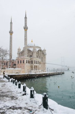 Ortakoy, İstanbul, Türkiye 'de karlı bir gün. Ortakoy Camii ve Boğaz Köprüsü Görünümü.