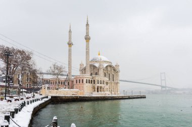 Ortakoy, İstanbul, Türkiye 'de karlı bir gün. Ortakoy Camii ve Boğaz Köprüsü Görünümü.