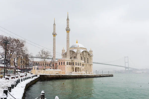 Ortakoy, İstanbul, Türkiye 'de karlı bir gün. Ortakoy Camii ve Boğaz Köprüsü Görünümü.