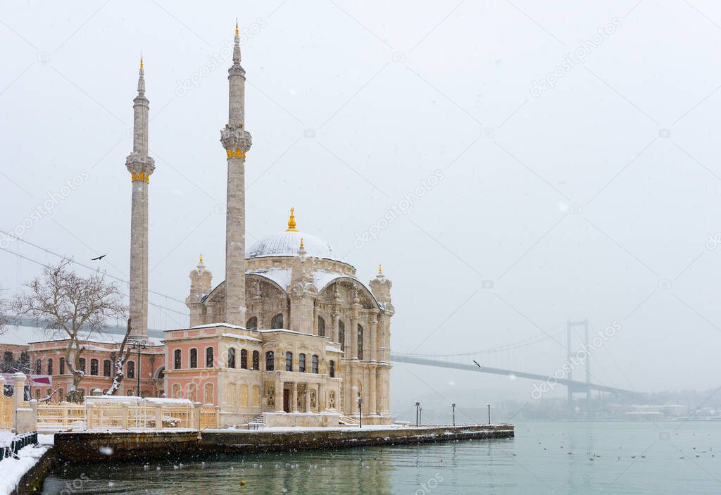 Snowy day in Ortakoy, Istanbul, Turkey. View of Ortakoy Mosque and Bosphorus Bridge.