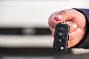 Arabanın anahtarını tutan bir adam. Yeni araba satışı, araba galerisi, araba satış anlaşmaları. Siyah araba anahtarı..