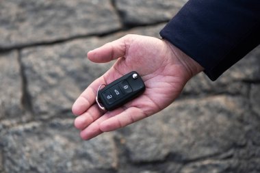 Arabanın anahtarını tutan bir adam. Yeni araba satışı, araba galerisi, araba satış anlaşmaları. Siyah araba anahtarı..