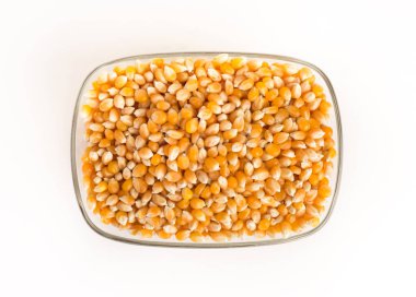 Beyaz arka planda cam kasede kuru mısır..