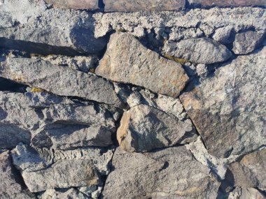 Duvarın dokusu büyük gri taşlardan yapılmıştır.