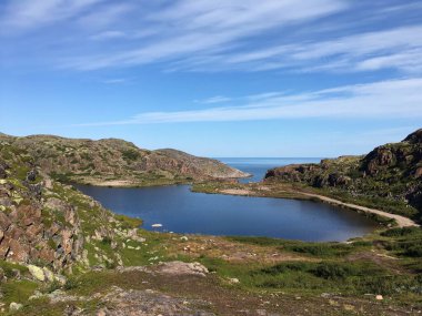 Bir yaz günü, deniz kenarındaki dağların arasında.