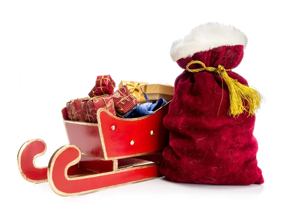 Roter Schlitten und Weihnachtsmannsack — Stockfoto