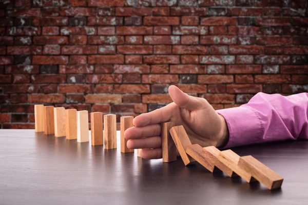 Stoppa risken dominoeffekt, affärsman med hand för förvaltning s — Stockfoto
