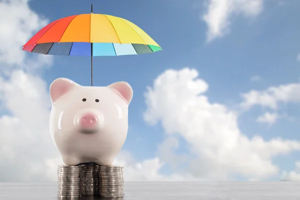 Piggy bank with colorful umbrella for saving money. Protection investment concept