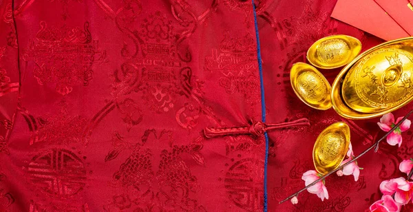 Chinese new year festival with home decoration and gold ingots on a blue color satin blanket .Chinese characters ZHAO CAI JIN BAO in the article refer to lucky fortune ,wealth, rich and money flow