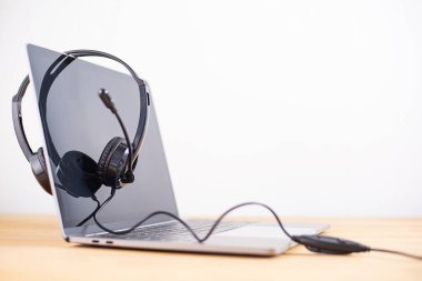 Diz üstü bilgisayar klavyesinde müşteriye oturum cevabı için VOIP kulaklığı olan çağrı merkezi ve müşteri hizmetleri desteği. Kopya alanı ile iletişim destek merkezi.