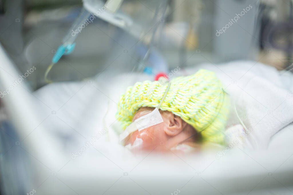 Newborn neonatal infant pulse oximeter premature baby. Children inside incubator.