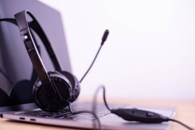 Diz üstü bilgisayar klavyesinde müşteriye oturum cevabı için VOIP kulaklığı olan çağrı merkezi ve müşteri hizmetleri desteği. Kopya alanı ile iletişim destek merkezi.