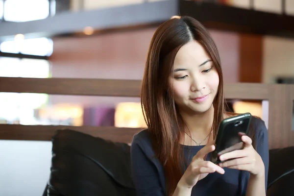 Joven chica asiática utilizar el teléfono móvil para información de búsqueda — Foto de Stock