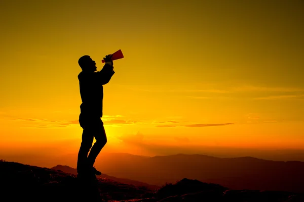 Businessman shouting for announce through a red loudspeaker — Stock Photo, Image