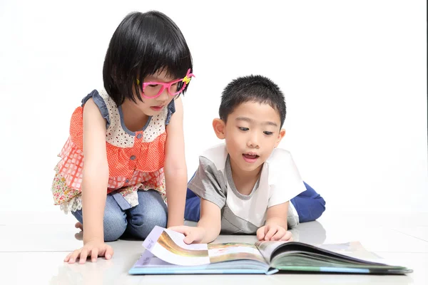 Los niños leen el libro juntos —  Fotos de Stock