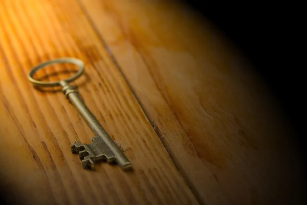 Single vintage key on the wood board.
