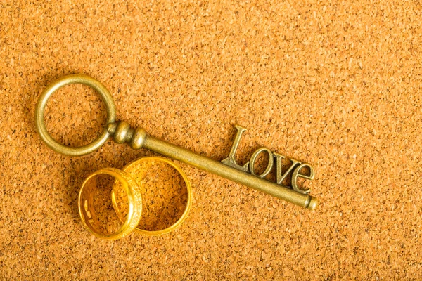 Gold heart key and engagement ring with vintage paper.