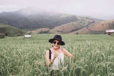 Mutlu Asyalı kadın Baan Pa Bong Piang, Chiang Mai, Tayland 'daki yeşil pirinç tarlalarında duruyor.