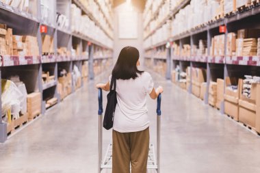 Alışveriş merkezinde virüs salgını sırasında ameliyat maskesi takan ve alışveriş yapan bir kadın.