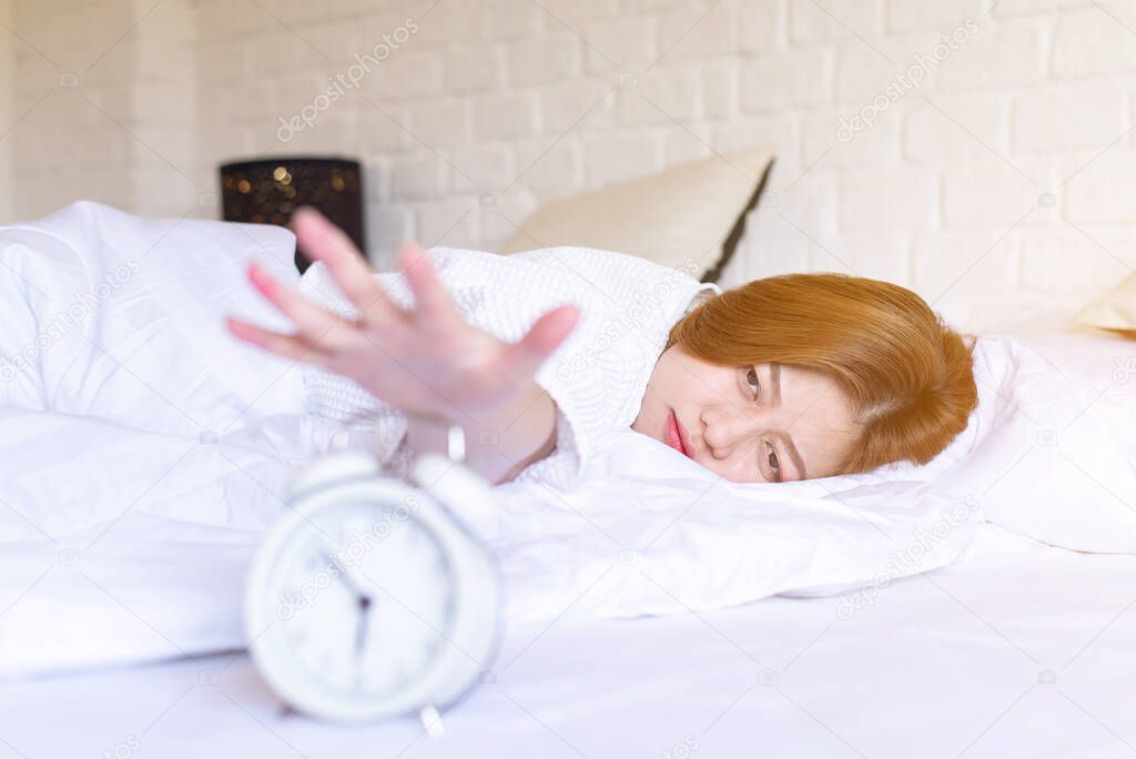 Asian woman hates getting stressed waking up late 6 o'clock,Alarm clock,Weekend morning