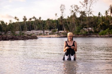 Mutlu Asyalı kadın denizde palet tutuyor, yaz tatili konsepti
