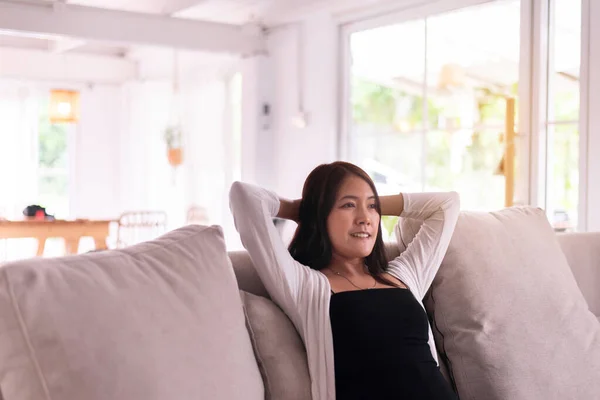 Gelukkig Aziatische Vrouw Zitten Bank Woonkamer Met Handen Het Hoofd — Stockfoto