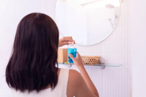 トイレで口をすすぐためにマウスウォッシュを使用する女性 新鮮な息 歯科医療の概念 — ストック写真