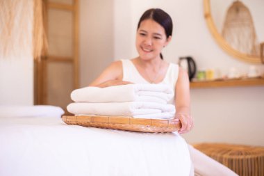 Hizmetçi kadın oteldeki yatağın üzerine temiz havlu koyuyor.