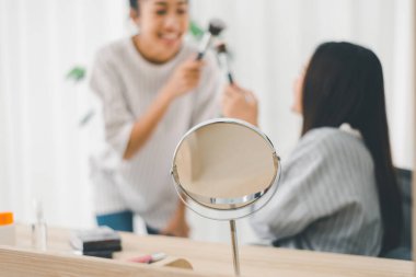 İki güzel Asyalı kadının evde birlikte makyaj yapması, güzel kadın konsepti.