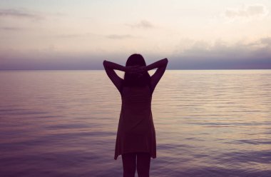 Denizde elleri havada mutlu bir kadın, Doğa ve Özgürlük kavramının tadını çıkarıyor.