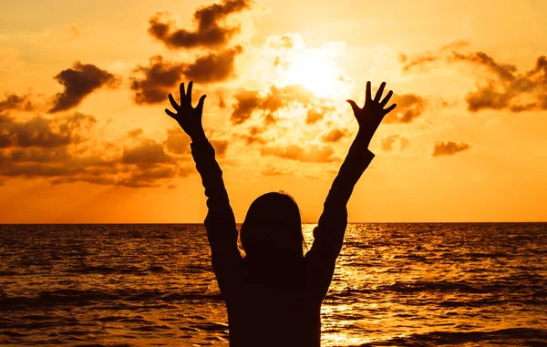 Sylwetka Szczęśliwej Kobiety Stojącej Podniesionymi Rękami Podczas Zachodu Słońca Morzu — Zdjęcie stockowe