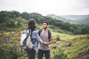 Ayakta duran ve konuşan, mutlu ve gülümseyen çiftler, doğada kamp yapmanın tadını çıkarıyorlar.