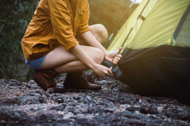 Traveller woman putting up a tent in nature,Enjoying camping concept