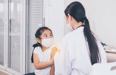 Koronavirüs sırasında yüz maskesi takan Asyalı çocuk ya da hastanede covid-19 salgını, aşı konsepti