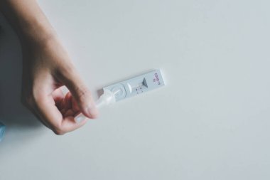 Hasta kadının sonuçlarına göre, evinde çovid-19 'luk kendi kendini test eden hızlı antijen test kiti var.