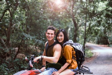 Yoldan çıkıp ATV 'de yan yana oturan mutlu ve gülümseyen bir çift.