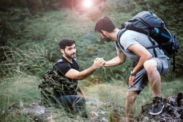 Sırt Çantalı Adam Arkadaşlarına Yardım Ediyor Kayaya Tırmanıyor Yardım Ediyor — Stok fotoğraf