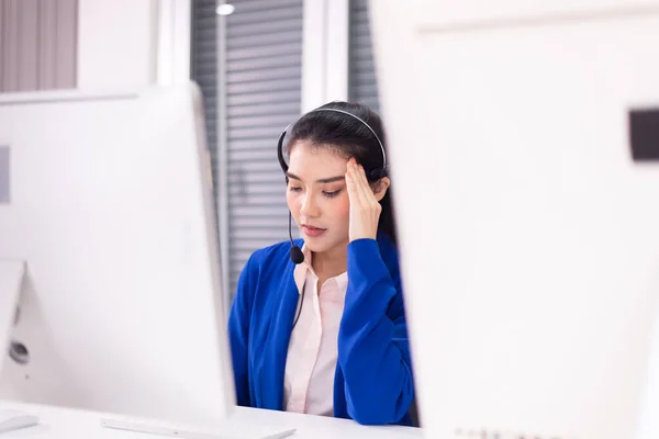 Çağrı merkezinde çalışırken baş ağrısı çeken Asyalı kadın müşteri hizmetleri acentesi