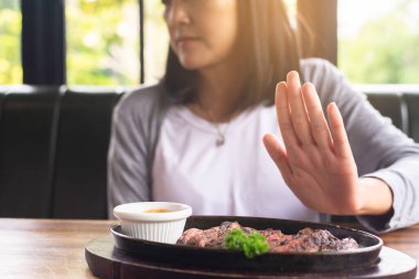 Hands woman refusing beef steak in restaurant,No meal,Vegetarian and vegan concept clipart