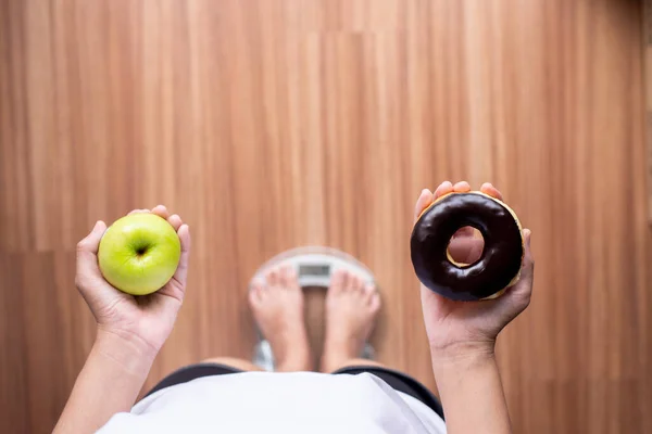 Kadın Elleri Yeşil Elma Çikolatalı Donut Tutarken Tartılırken Sağlıklı Beslenme — Stok fotoğraf