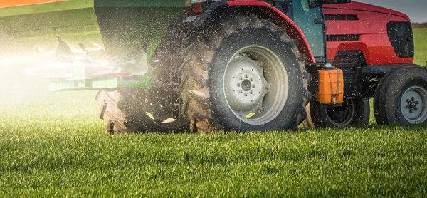 Traktor, hnojení v poli — Stock fotografie