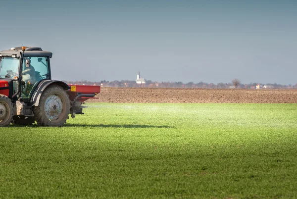 Trekker bemesten in veld — Stockfoto