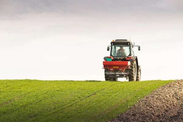 Traktor, hnojení v poli — Stock fotografie