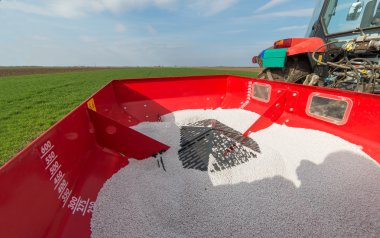  tractor fertilizing in field  clipart