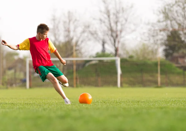 Junge tritt Ball aufs Tor — Stockfoto