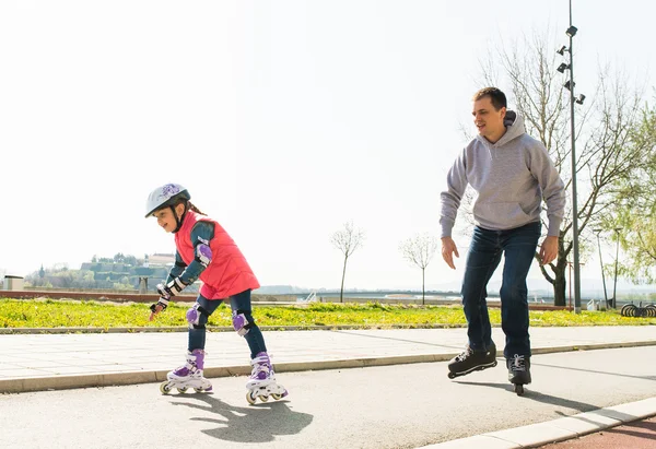 Menina e pai em patins — Fotografia de Stock